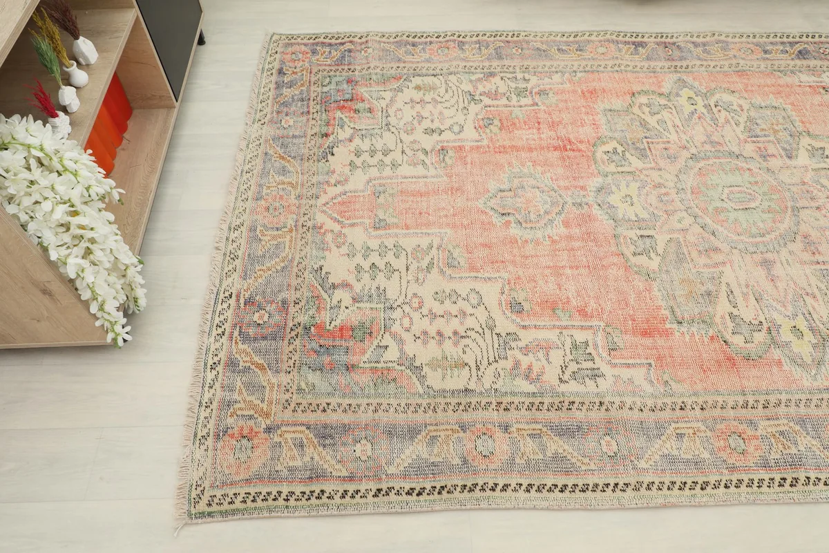 Detail of the rug's patterns and colors from an elevated angle in a room setting