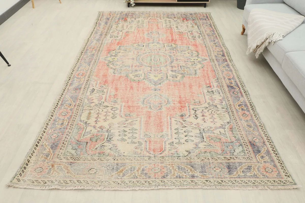 Full overhead view of the rust and blue vintage rug placed in a light-filled room