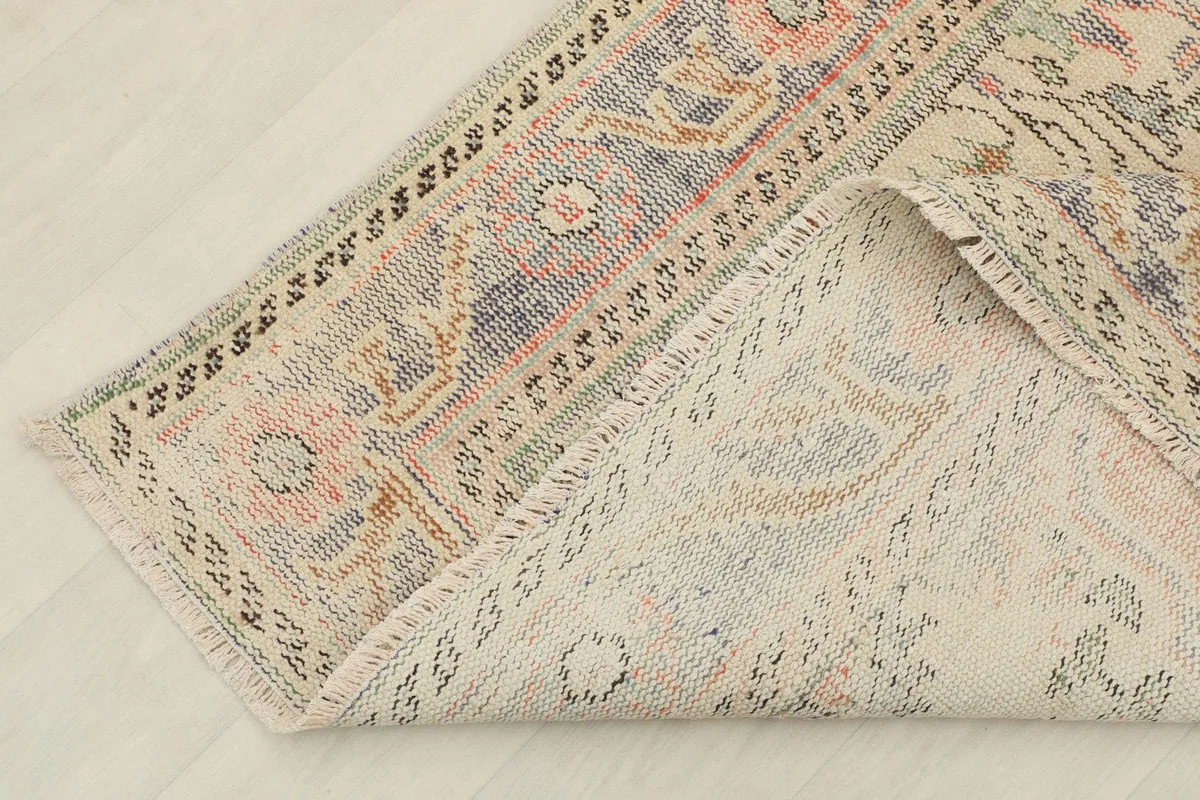 Corner of the rug folded back to reveal the reverse side and construction