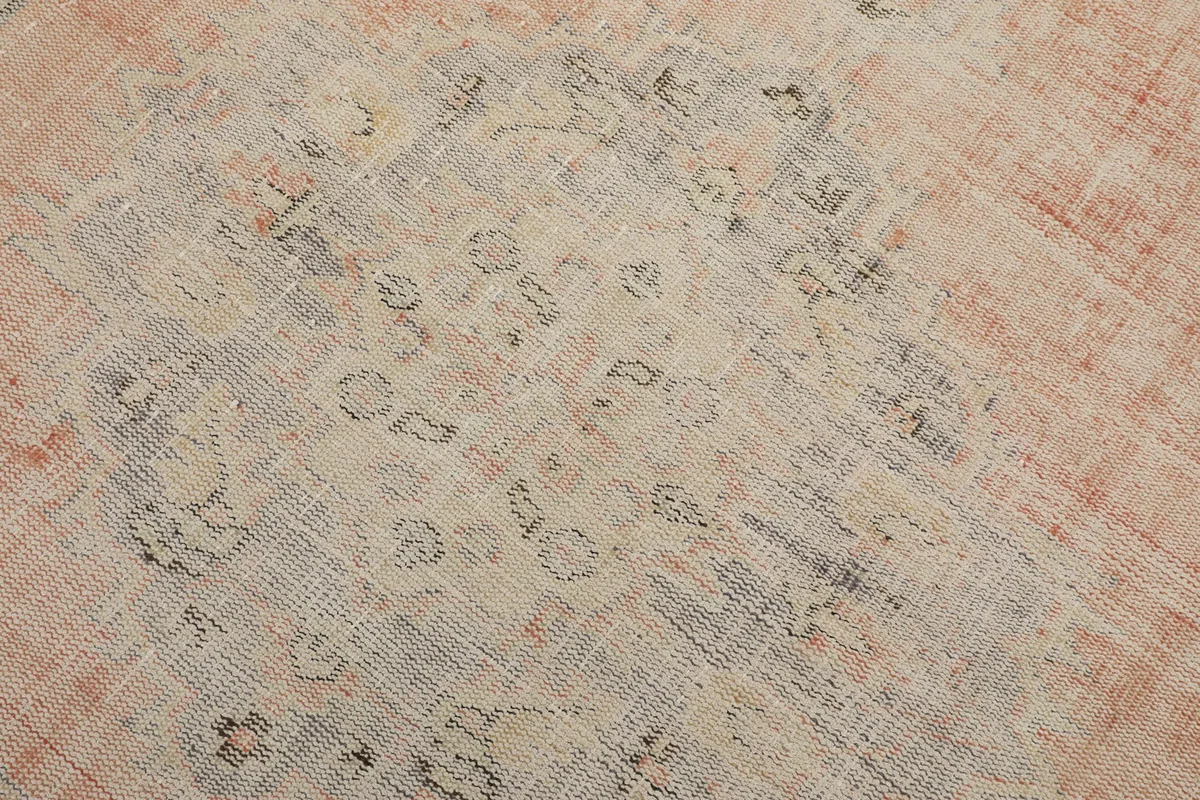 Close-up detail of the central medallion and floral motifs in gray and beige
