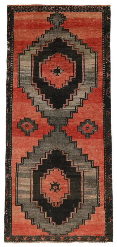 Top view of a red, gray, and black geometric vintage Anatolian area rug on a white background.