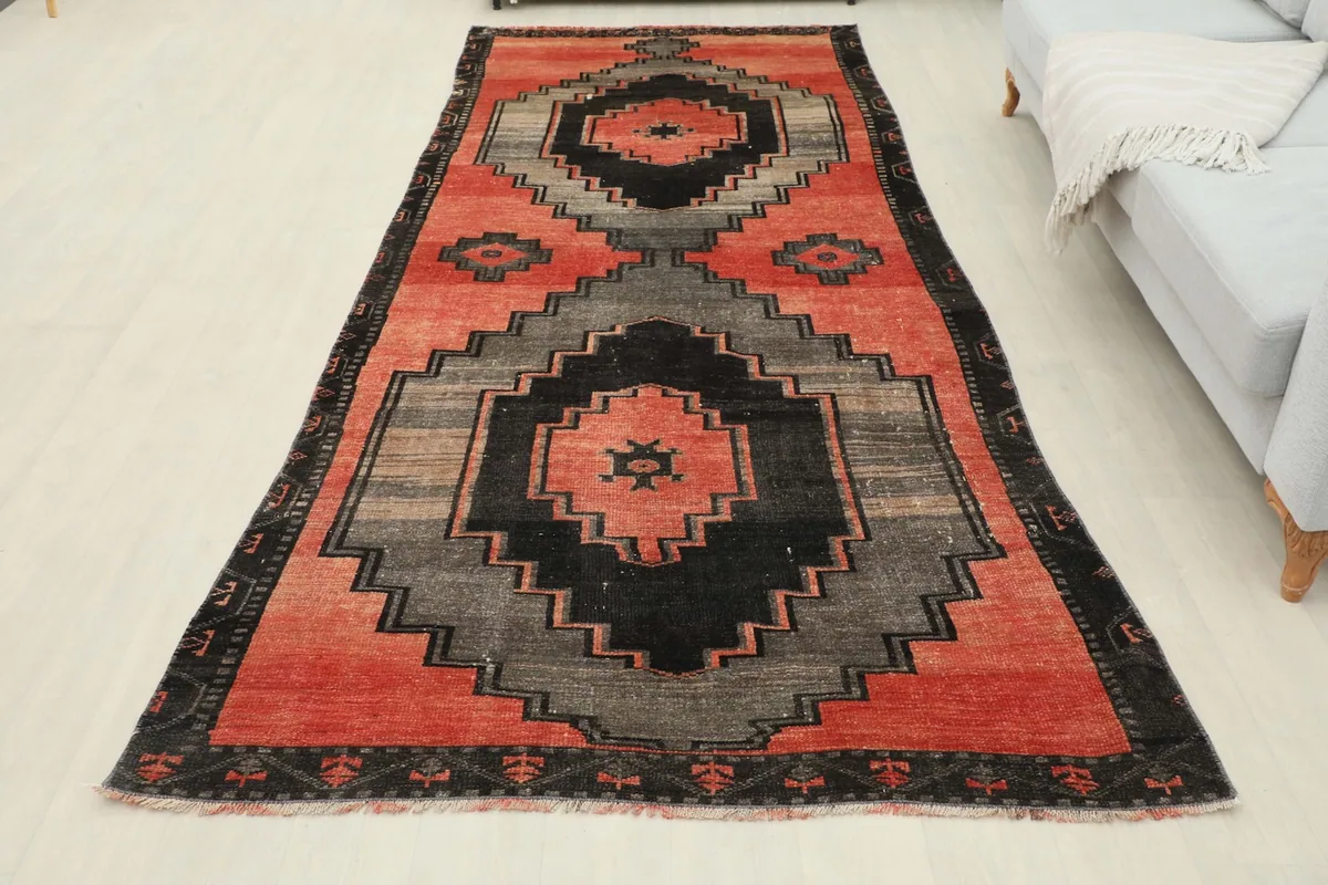 Full overhead view of the red, gray, and black geometric vintage Anatolian area rug in a room.