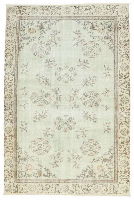 Full overhead view of the 5'3" x 7'10" soft green floral vintage Anatolian rug on a white background.