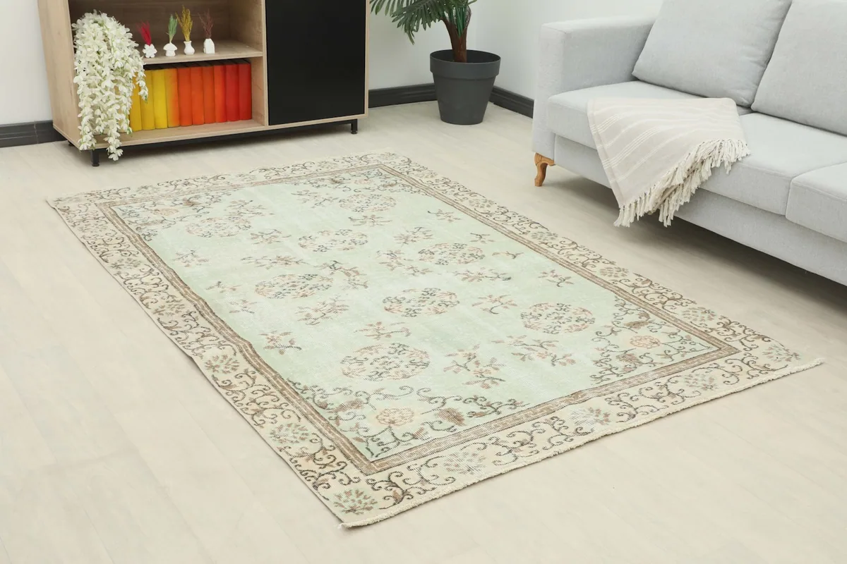 Angle view of the hand-knotted rug showcasing its soft green and brown tones in a contemporary room.