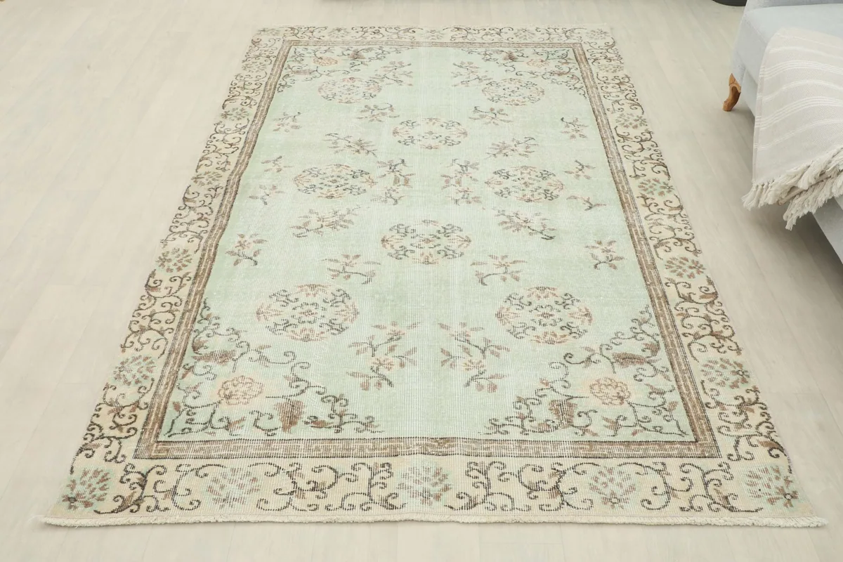 Full overhead view of the 5'3" x 7'10" soft green vintage Anatolian rug in a room setting.