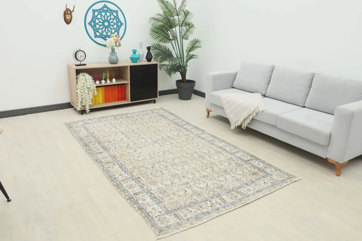 Ivory and charcoal vintage area rug in a modern living room setting with a light gray sofa.