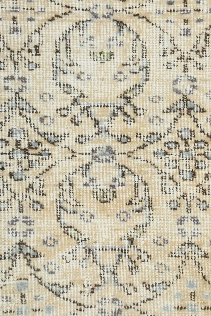 Very close detail of the hand-knotted wool pile and faded charcoal and gray patterns.