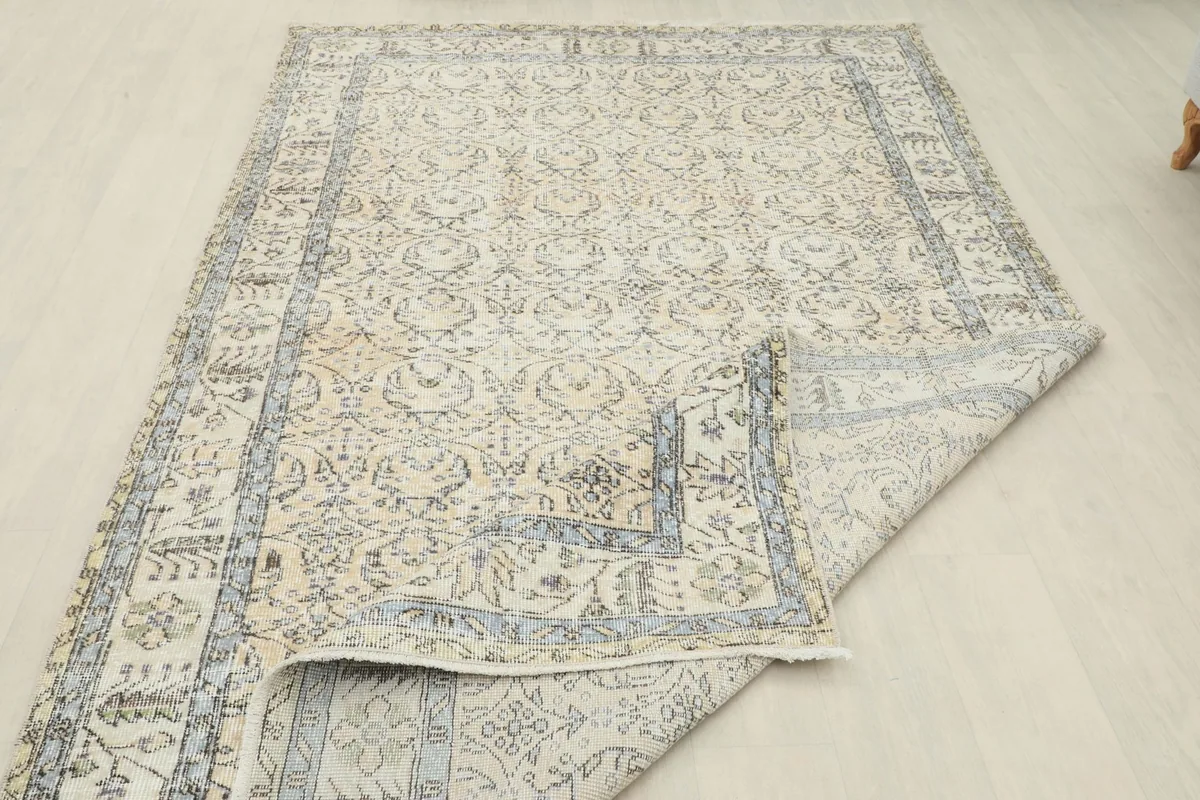 View of the rug with a corner folded back, revealing the wool pile and cotton foundation.