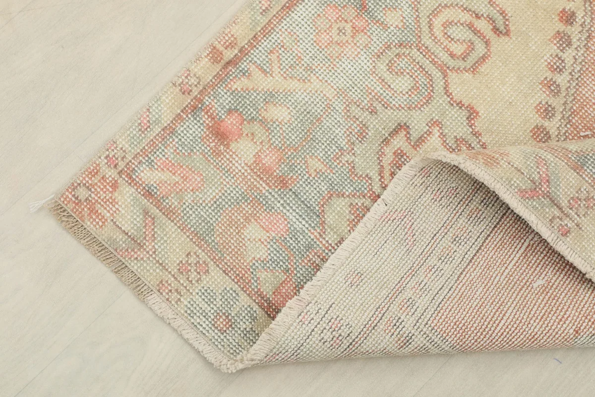 Corner of the rug folded back, showing the back of the hand-knotted construction