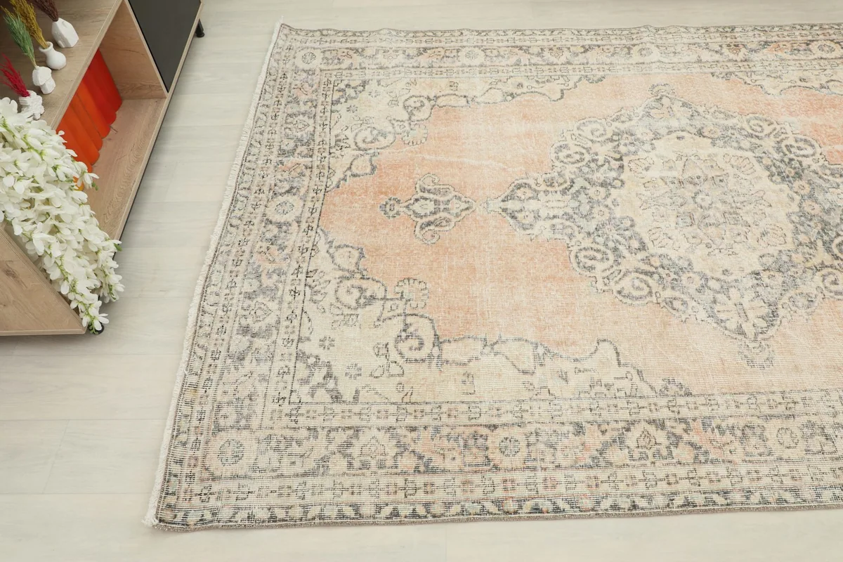 Angled view highlighting the rug's distressed texture and intricate border design.