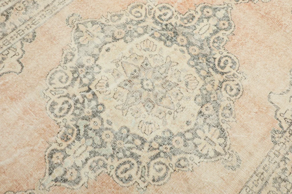 Detailed close-up of the rug's central medallion with gray and ivory motifs.