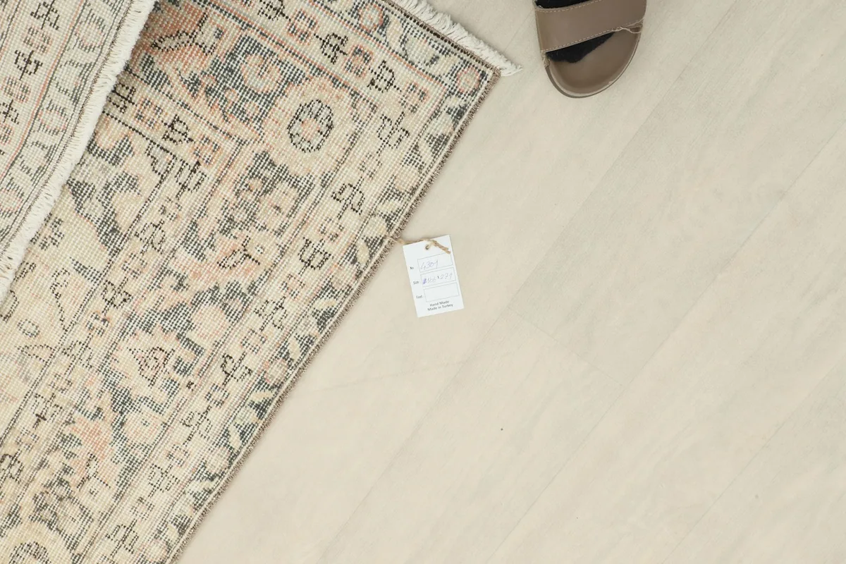 View of the rug's reverse side and tag, showing the hand-knotted craftsmanship.