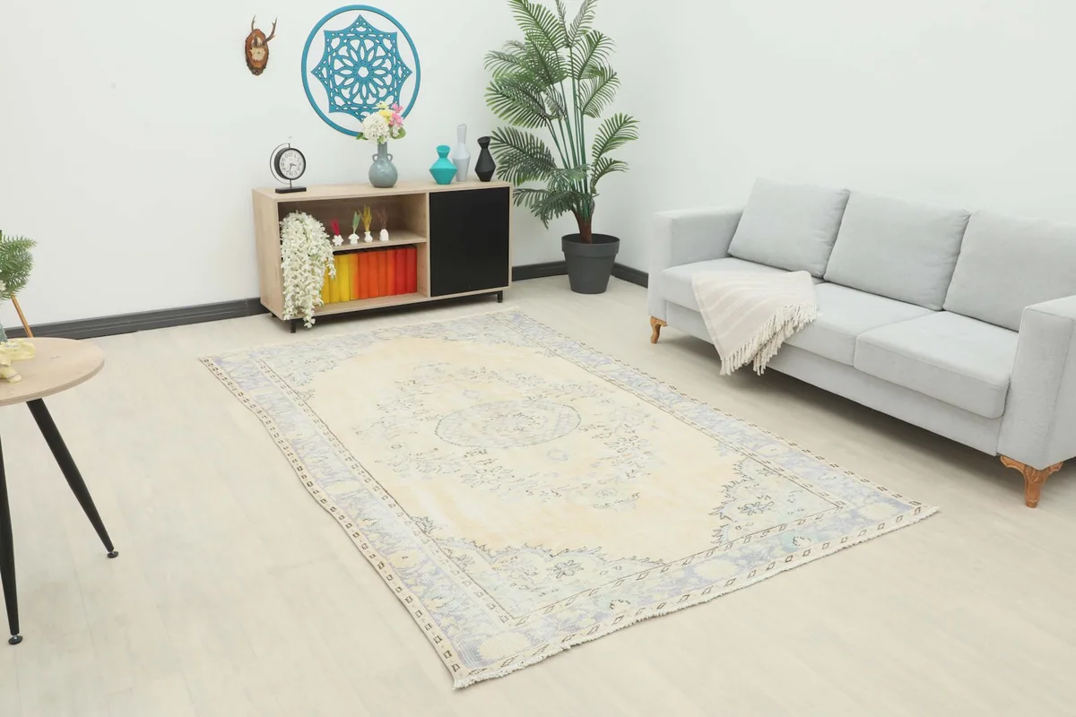 Vintage ivory and blue rug in a living room setting with a light gray sofa