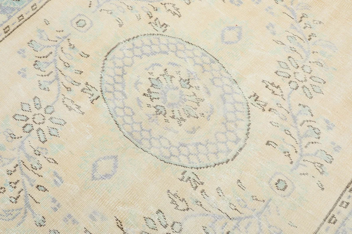 Detailed view of the central medallion and surrounding faded blue patterns on the rug