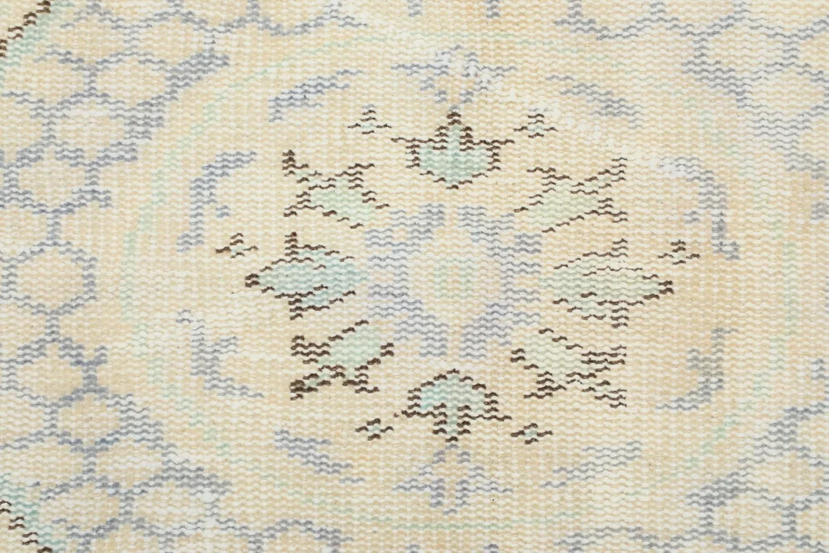 Close-up of the low wool pile texture and muted blue and ivory knotting