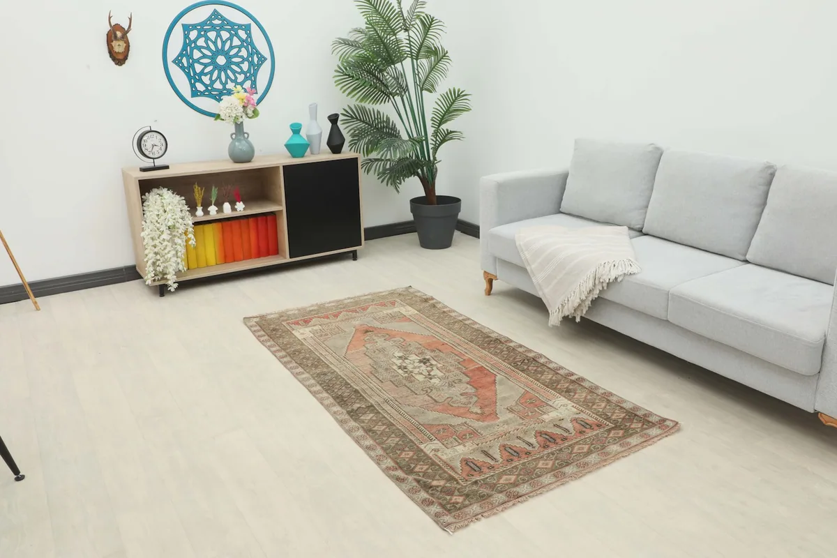 Vintage rust and gray geometric rug placed in a living room setting with a sofa and decor
