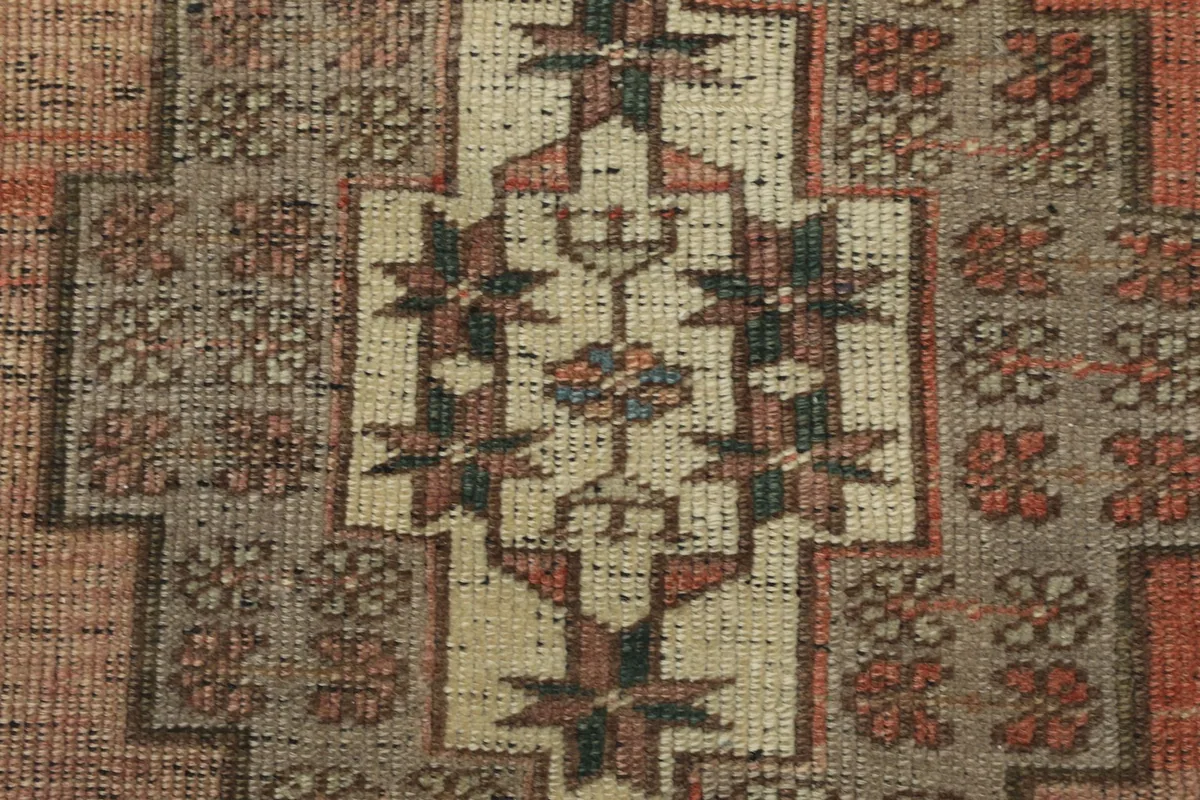 Close-up of the intricate wool pile and tribal motifs within the central medallion