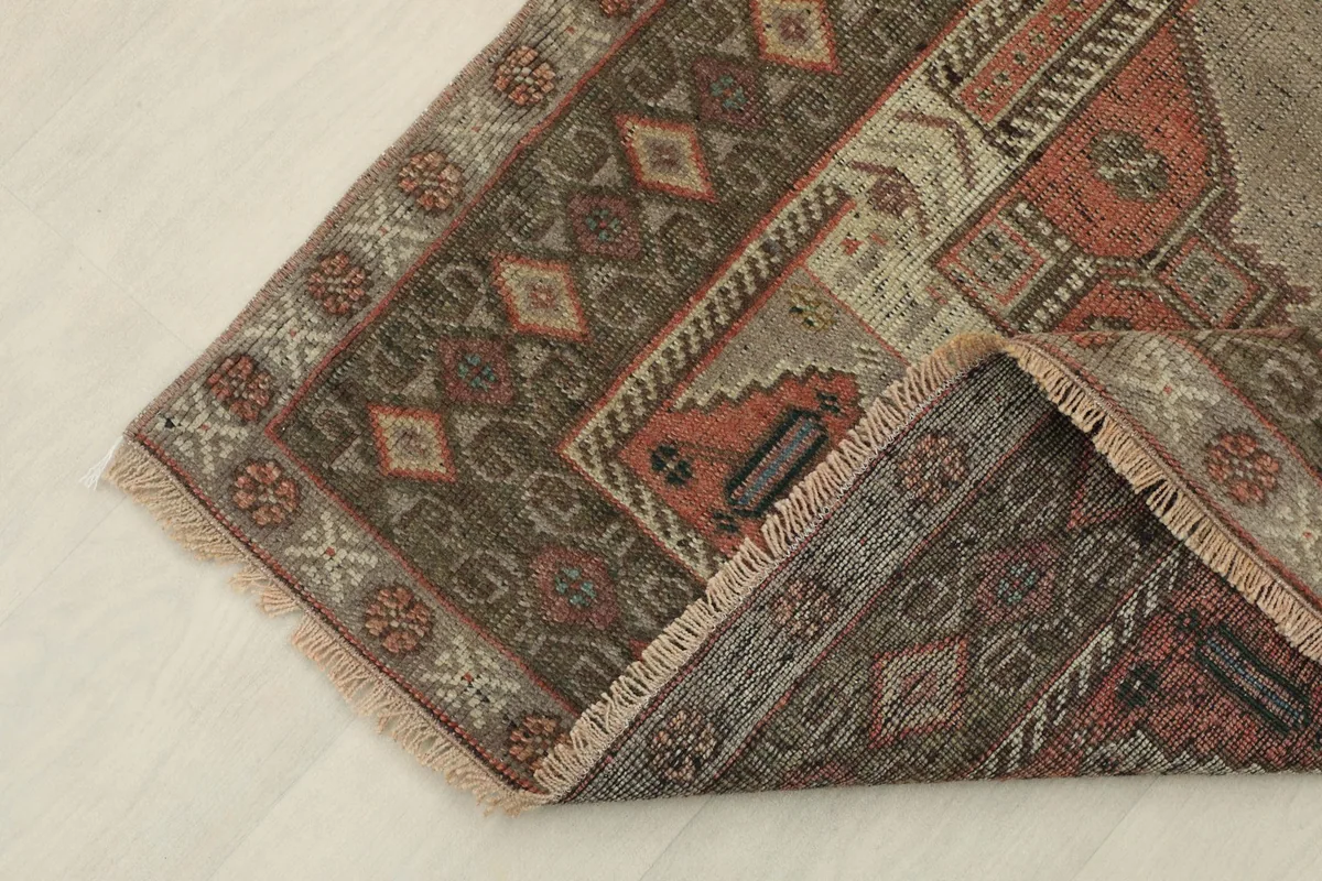 Corner of the rug folded to show the hand-knotted wool pile and cotton foundation