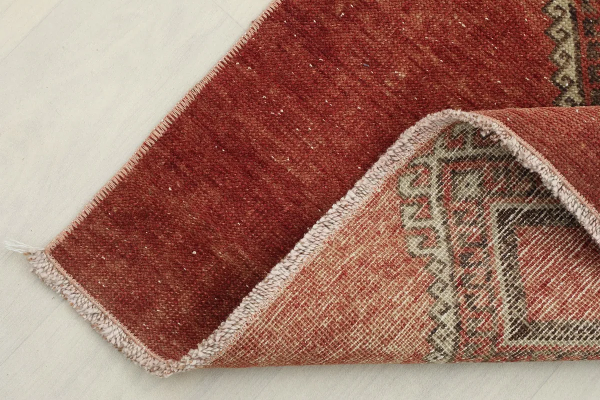 View of the rug's back and folded corner, revealing the cotton foundation and hand-knotted construction
