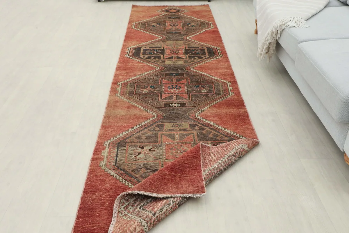 Runner rug partially folded, showing the full length and the reverse side of the wool pile