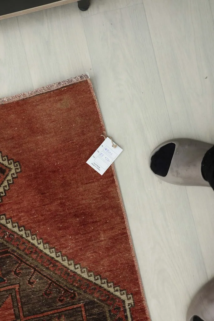 Overhead view of the rug's corner with a small label, showing its texture and color