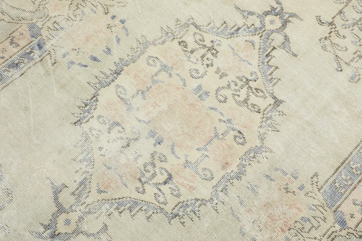 Detailed view of the central medallion on the Faded Gray Rose Medallion Rug, showing faded colors.