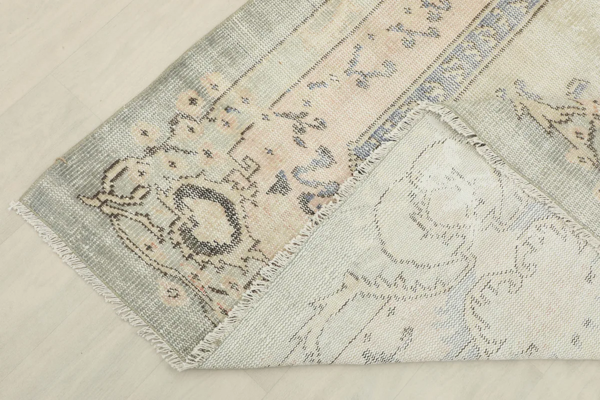 Close-up of the Faded Gray Rose Medallion Rug's back, showing the hand-knotted cotton foundation.