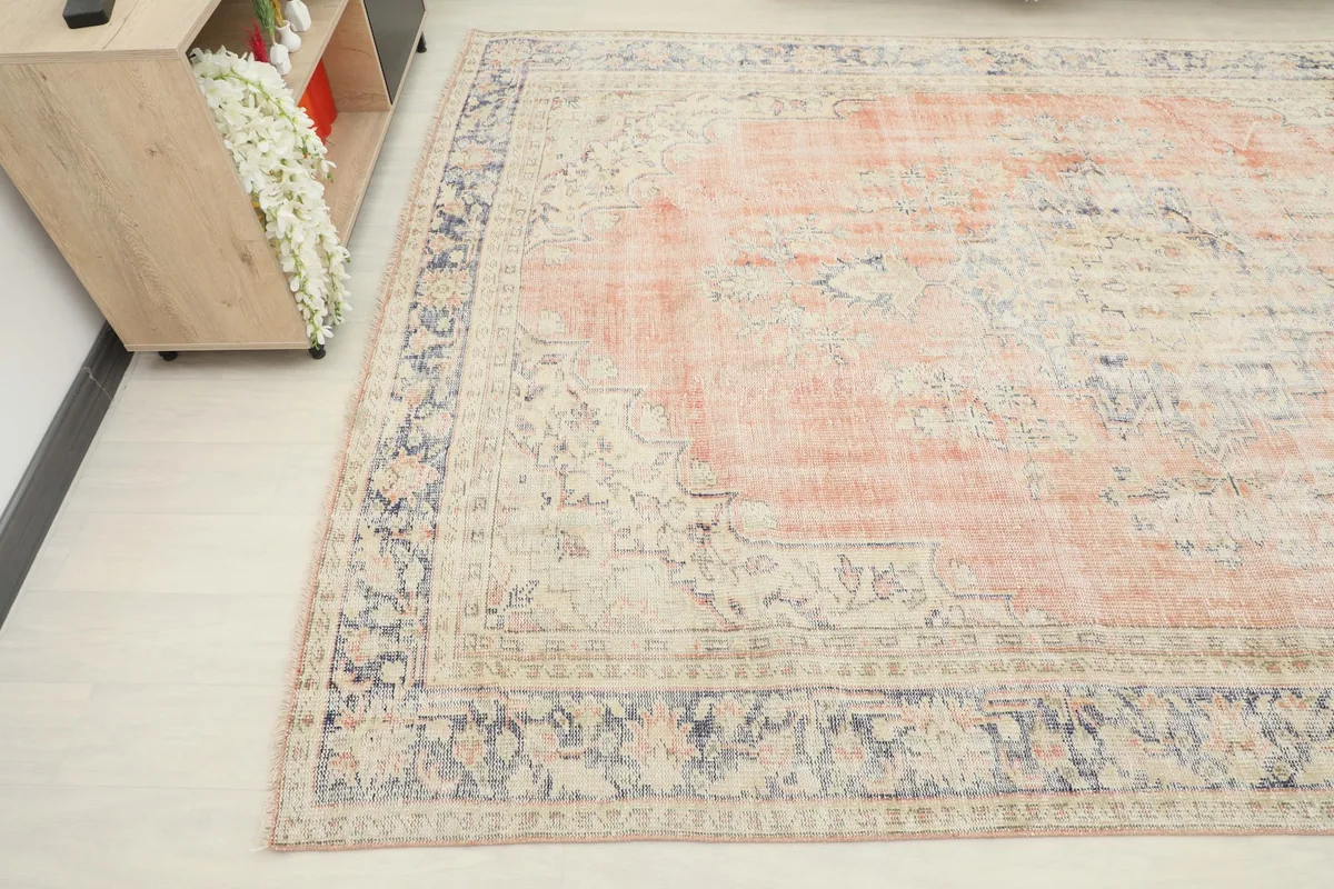 Corner view of the rug, highlighting the ivory field and floral border details
