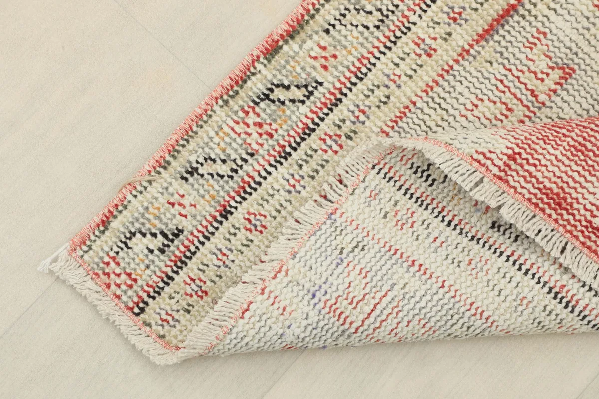 Detailed underside view of the rug, revealing the hand-knotted cotton foundation and wool pile