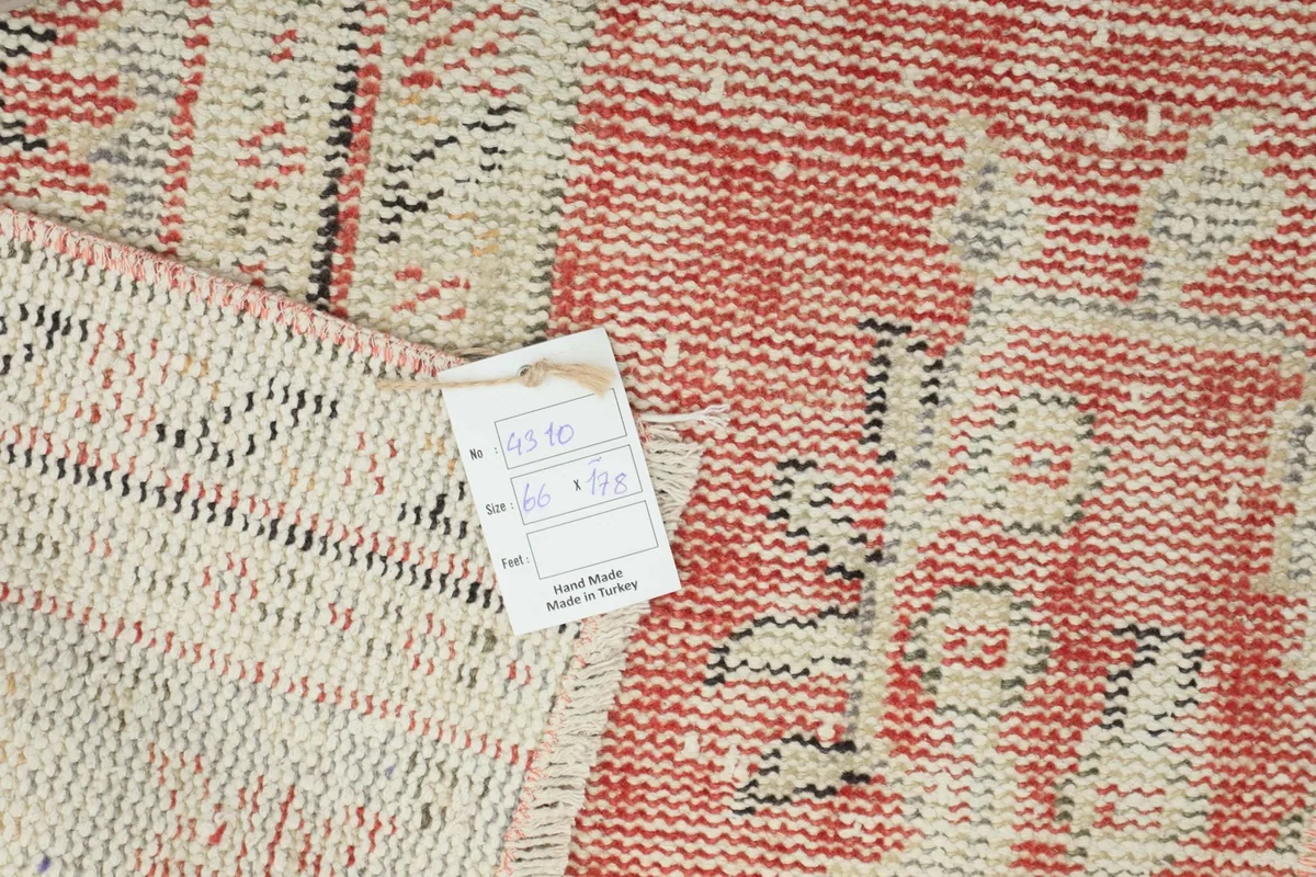 Close-up of the rug's back with a label indicating 'hand made in Turkey' and dimensions in cm