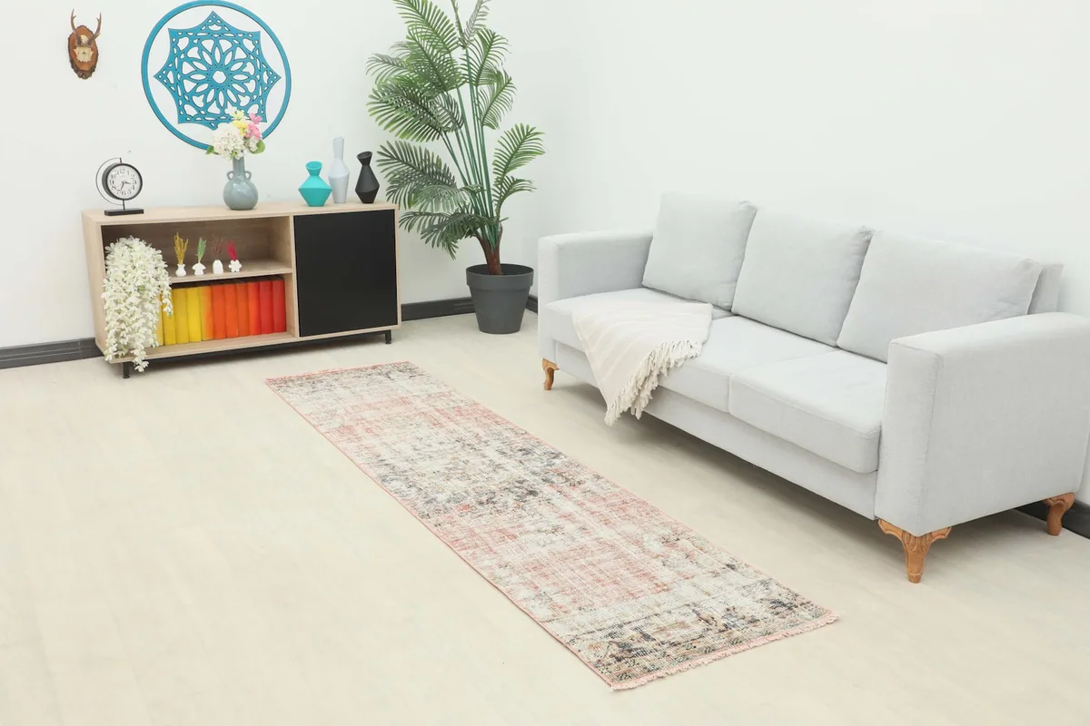 Vintage Anatolian runner rug displayed in a living room setting, extending in front of a sofa