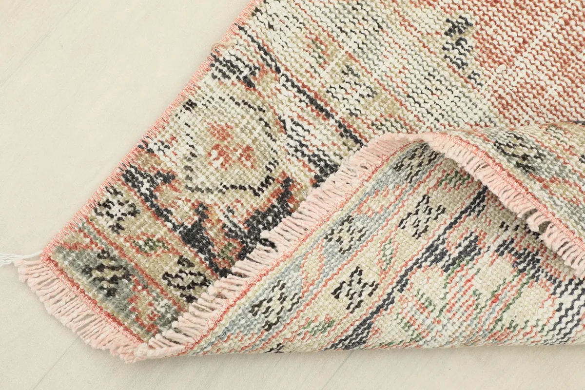 Corner of the rug folded to show the hand-knotted cotton foundation on the back