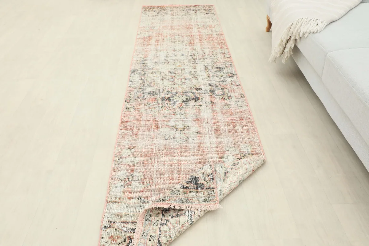 Runner rug partially folded to show its flexibility and thickness in a room setting