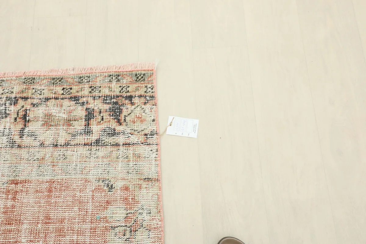 Top-down view of a section of the rug, next to a white measurement tag