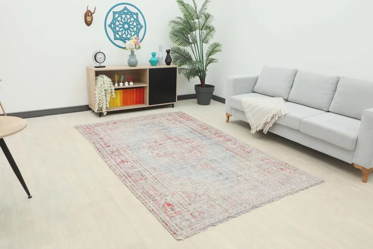 Full view of the rose and gray rug in a living room with decor elements