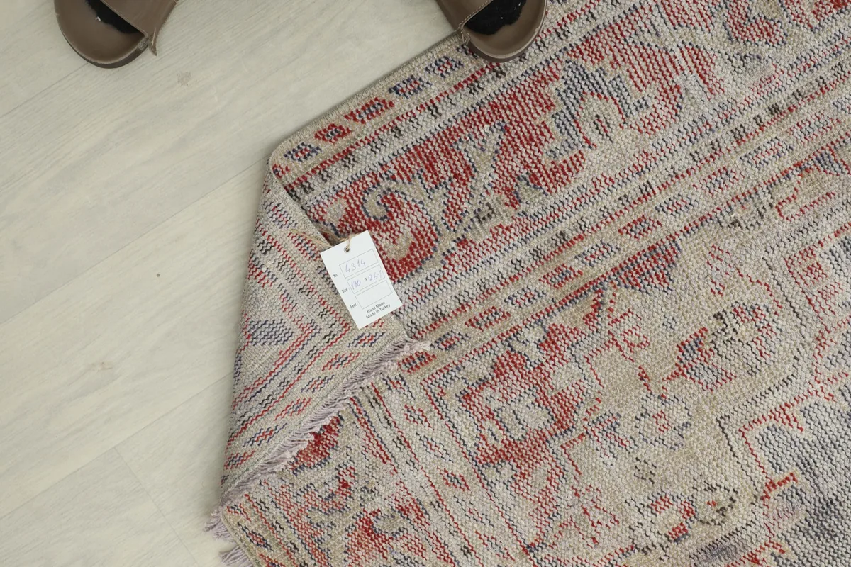 Overhead view of the rug with a tag near the edge, next to a pair of shoes