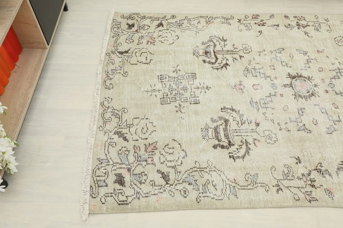 Angled view of the rug's top left corner, revealing intricate floral and geometric details