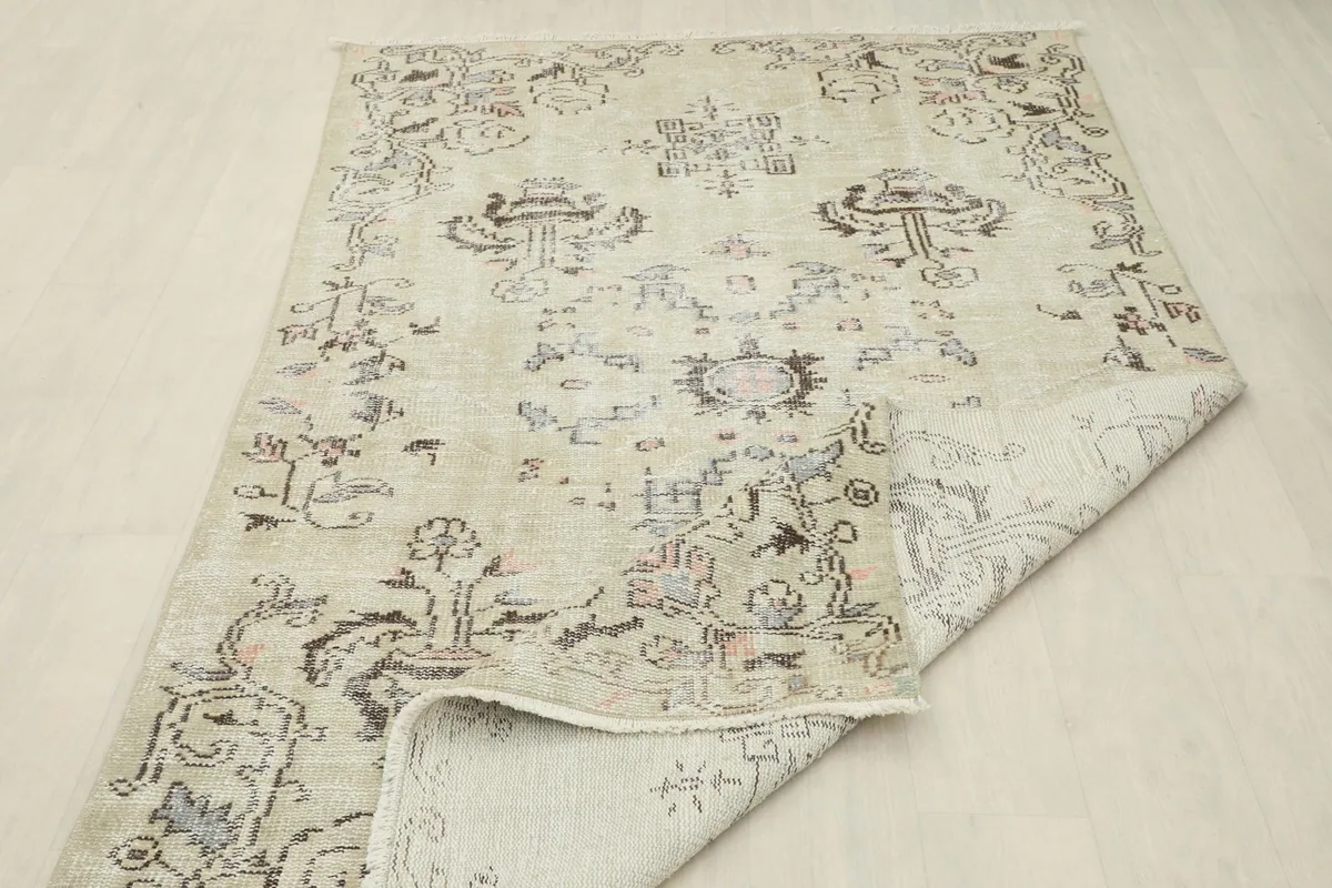 Angled view of the rug with a corner folded over, displaying the overall pattern and construction