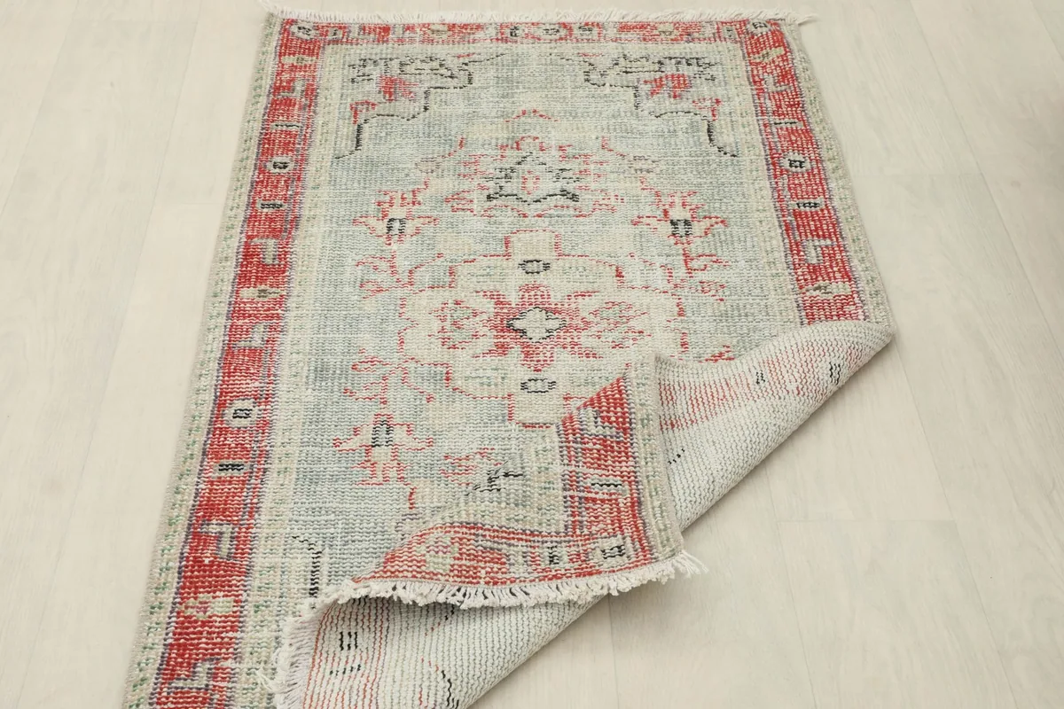 The rug partially folded over to display its thickness and the reverse side