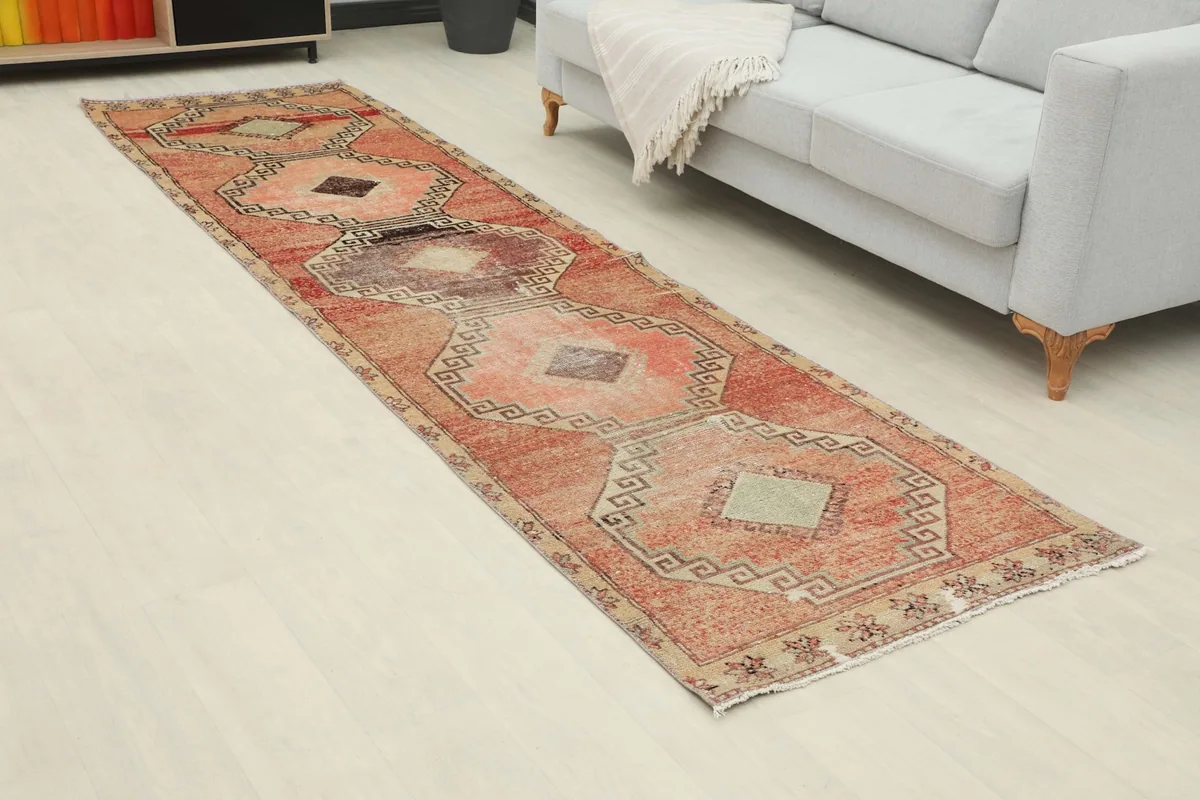 Angled view of the runner rug extending across a room with light flooring