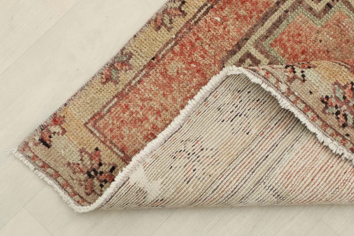 Corner of the runner rug showing the hand-knotted cotton foundation and wool pile