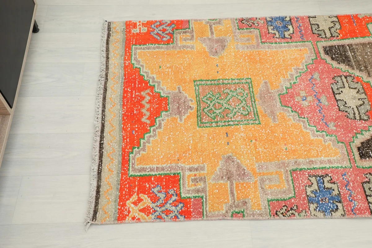 Close-up of the orange and black sections with geometric motifs and fringe