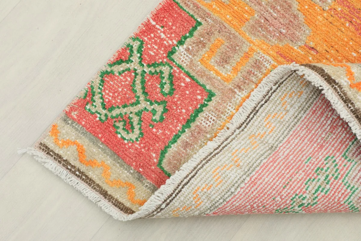 Close-up of the runner's folded edge, revealing the hand-knotted wool pile and cotton foundation