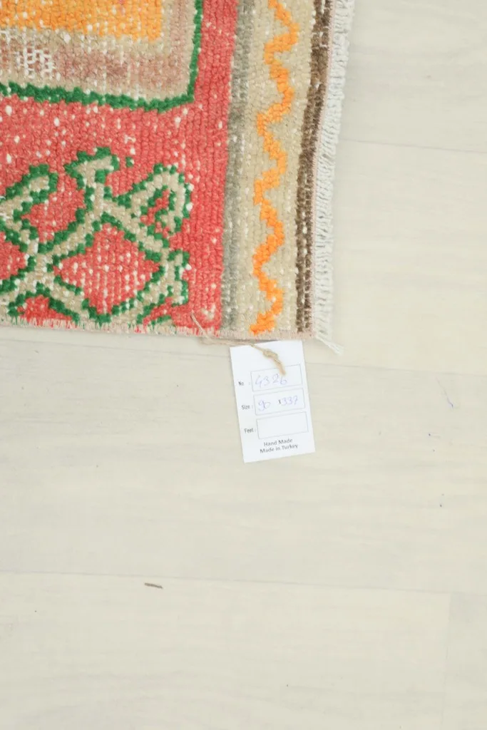 Corner of the runner rug with a product tag on a white floor
