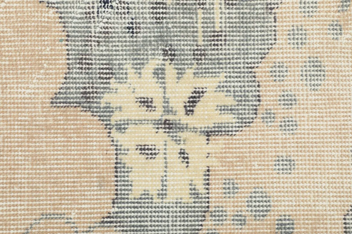 Macro shot of the wool pile, revealing the texture and subtle color variations of the motifs.
