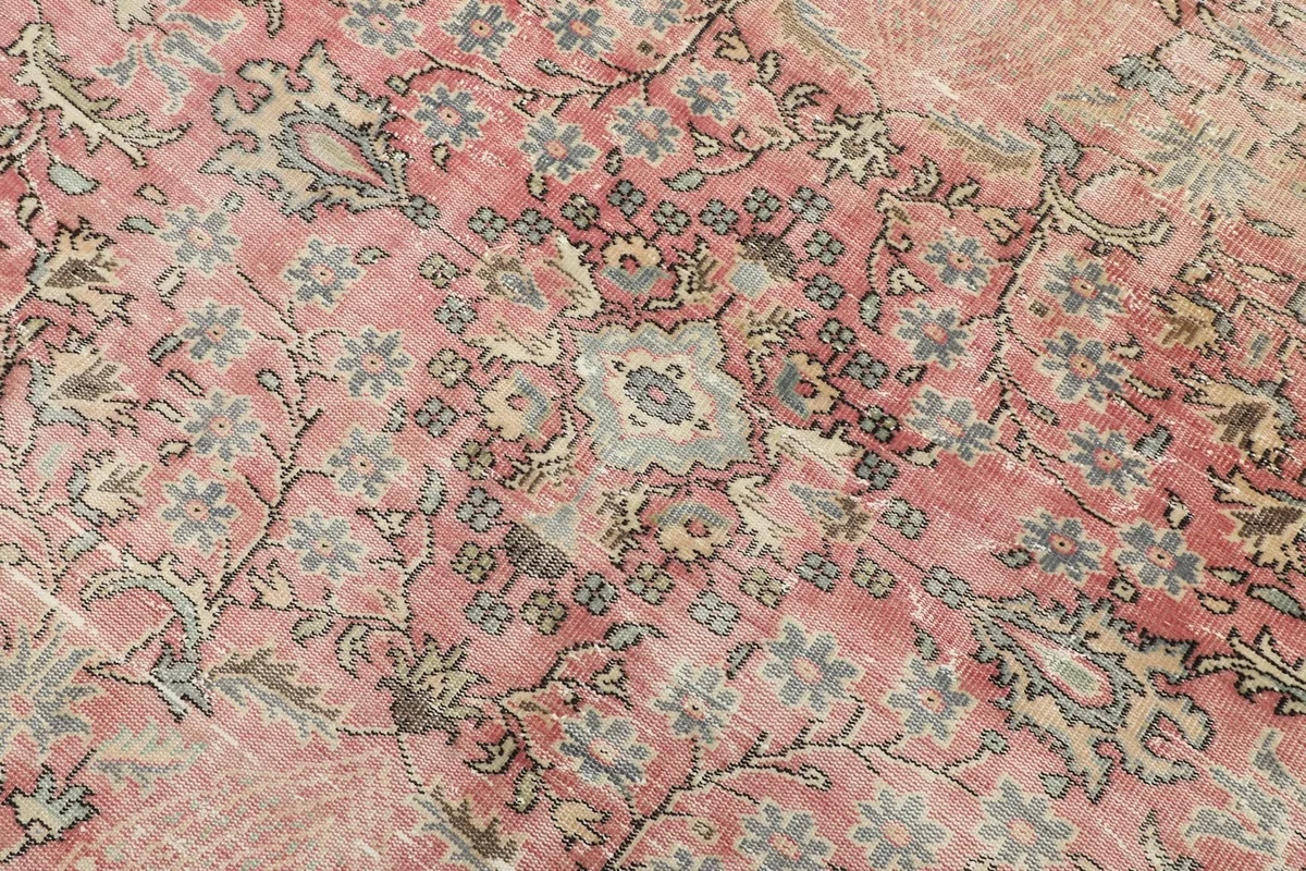Detailed view of the rose field with gray and beige floral motifs and faded pile texture