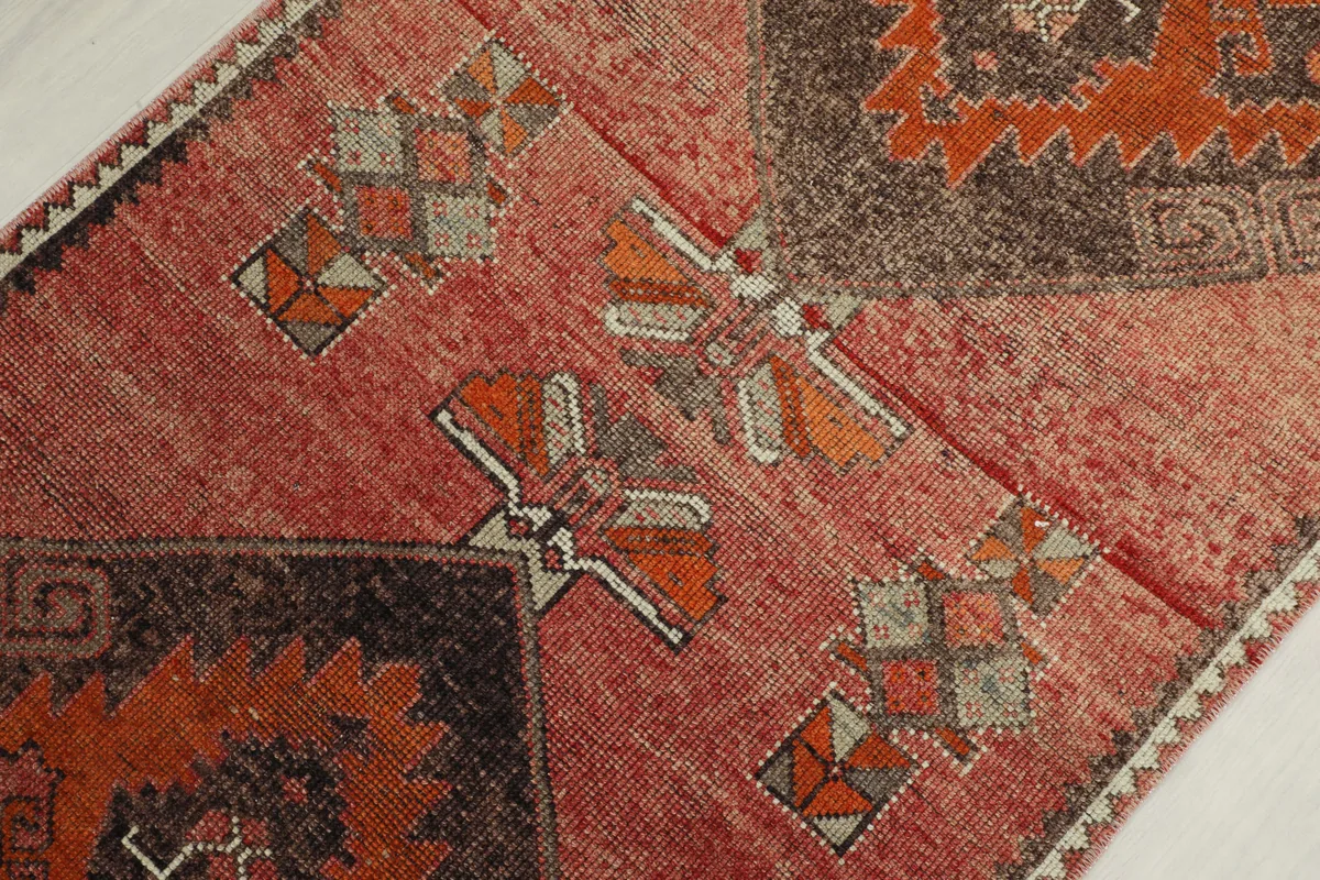 Close-up of the Rose Orange Geometric Anatolian Runner's mid-section, highlighting faded colors and motifs.