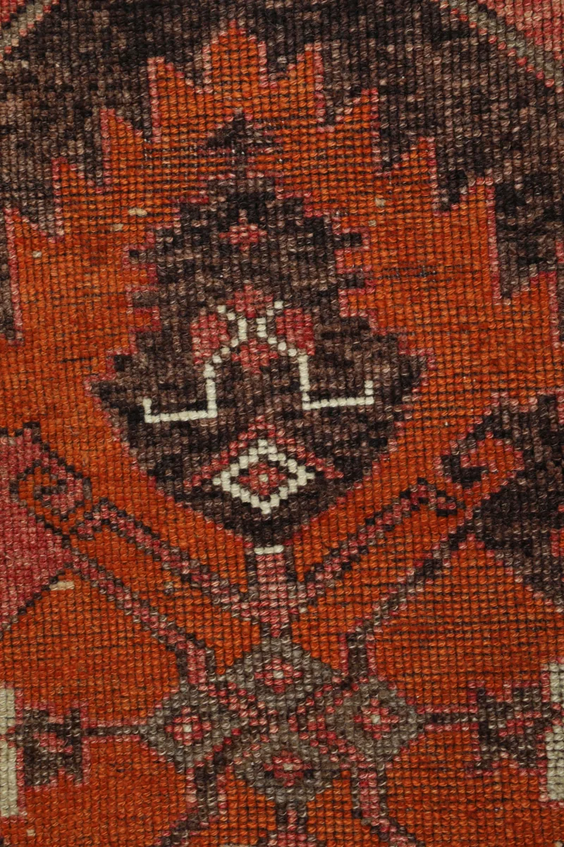Extreme close-up of the Rose Orange Geometric Anatolian Runner's wool pile and knotting.