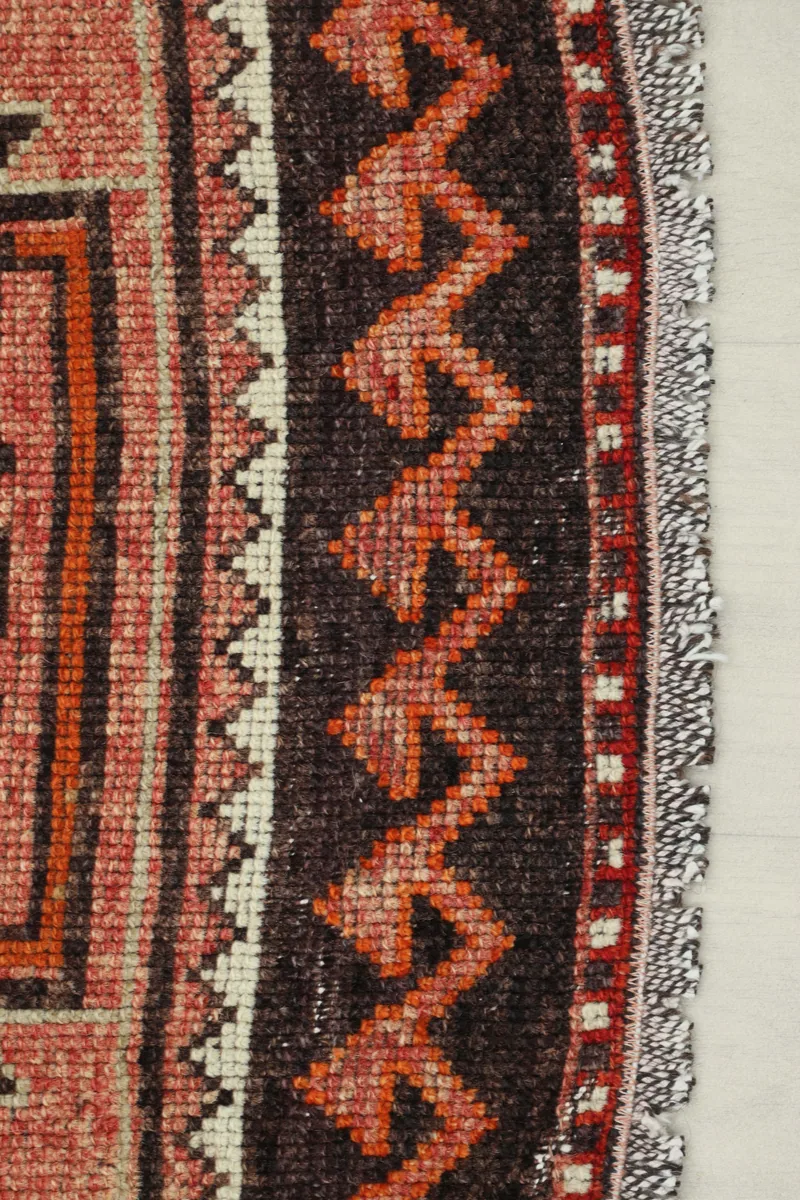 Detail of the Rose Orange Geometric Anatolian Runner's border, showing intricate zigzag patterns.
