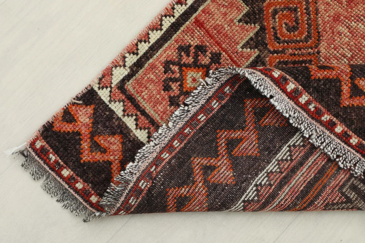 Rose Orange Geometric Anatolian Runner folded to show its flexibility and thickness.